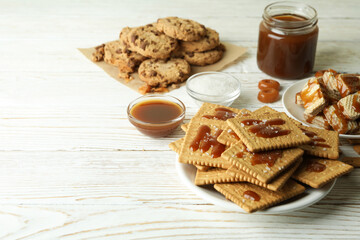 Tasty snack concept with cookies with caramel on white wooden table