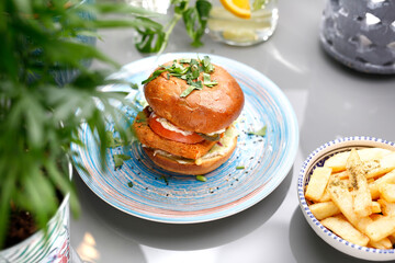 Vegetarian burger with tofu cheese and vegetables. A colorful appetizing dish. Culinary photography, food styling.