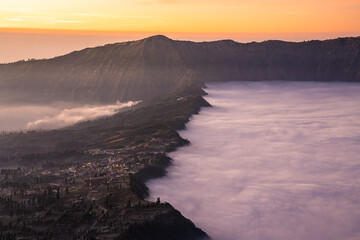 Beautiful sunrise with sea of fog at Cemoro Lawang village at mount Bromo volcano in, East Java, Indonesia..
