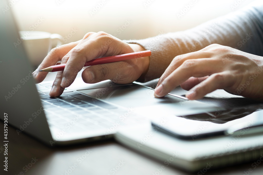 Poster close-up of man hands using and typing keyboard of laptop computer on office desk. workspace, busine