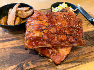 Grilled barbecue pork spare ribs rack with fried potatoes and coleslaw.