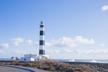 Fototapeta na wymiar Cap d'Artrutx lighthouse on the edge of a cliff protecting the ships of the Mediterranean sea