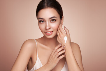 Beauty woman applying cream on her hands. Young woman with clean fresh skin - obrazy, fototapety, plakaty