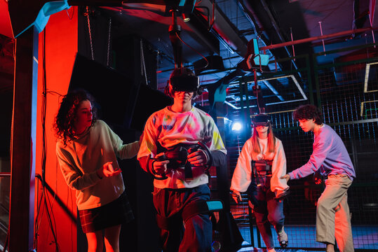 teenagers gaming in vr headsets near interracial friends