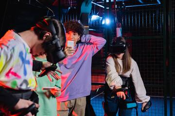 teenage boy taking photo of gamers in vr play zone