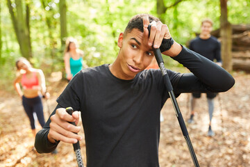 Exhausted young man doing Nordic walking