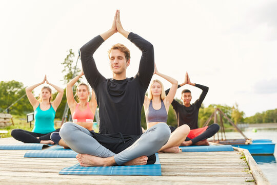 Group of people doing yoga meditation in nature