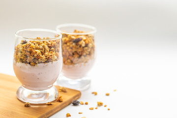 muesli with yogurt in a glass on a wooden board, free space