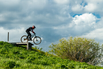 Fototapeta na wymiar Mountain biker is jumping from the drop