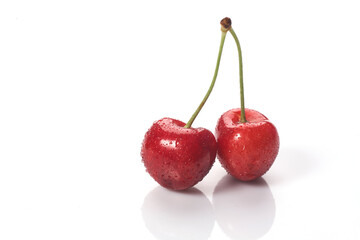 Red cherries with water droplets, close-up. Isolated on white background.