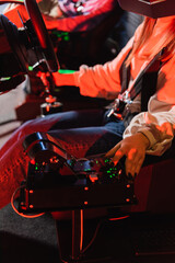 cropped view of teenager operating gear box while gaming in car racing simulator