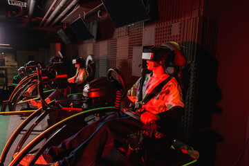 Fototapeta na wymiar teenage gamers racing in car simulators in vr play zone