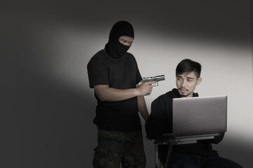 Terrorist using gun threaten hacker for damage in security network.