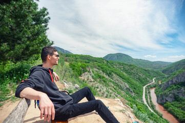 Naklejka na ściany i meble A man is sitting on the bench at Sićevačka klisura (Sicevo gorge)
