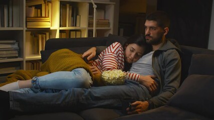 couple watching television at home - Powered by Adobe