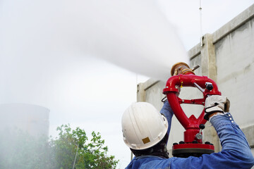 Worker are test the fire hose valve to connect the fire hose at construction site in chemical plant...