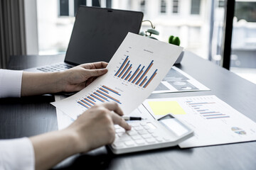 The head sales department checks the monthly sales datasheet for the salesperson to calculate the monthly commission, she looks at the document and presses the calculator. Sales management concept