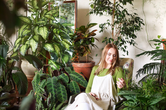 Relaxed Woman In Room With Green Plants