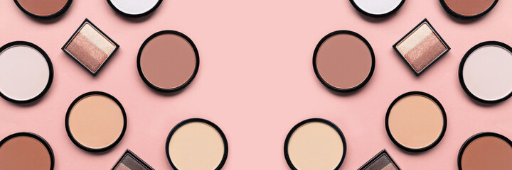 Makeup. Cosmetic products. Beige blush, eyeshadow and compact face powder on pink background....
