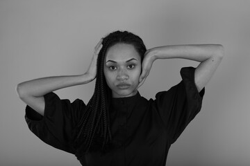 Black and white portrait of beautiful woman with hands near head