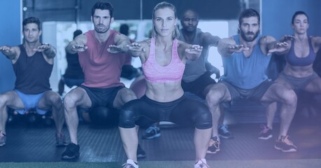 Composition of fit men and women squatting in gym