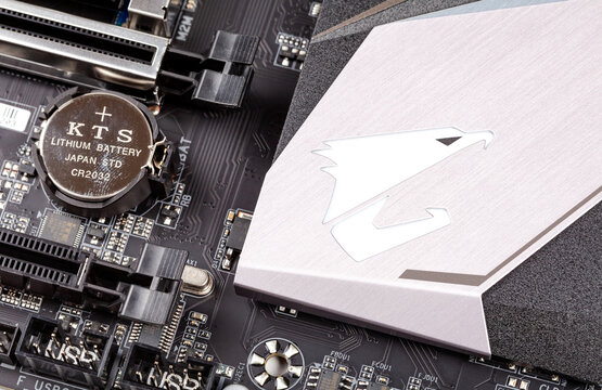 Z390 Aorus Pro Wifi high end motherboard, Gigabyte Aorus logo and bios cmos battery detail, macro, KTS cr 2032, closeup, top view, from above, pc components