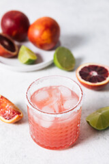 Blood orange margarita cocktail on white table background. Summer cocktails, refreshing drinks, cocktail party concept.