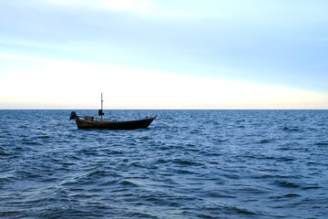 A small fishing boat by the sea in the evening