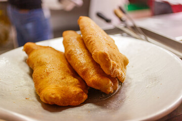 Pizze fritte napoletane ripiene di salame e ricotta appena cotte e pronte per essere vendute
