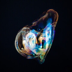 Amorphous and colorful isolated soap bubble with black background.