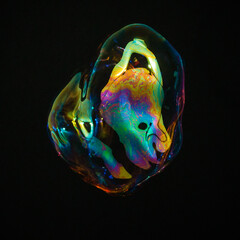 Amorphous and colorful isolated soap bubble with black background.