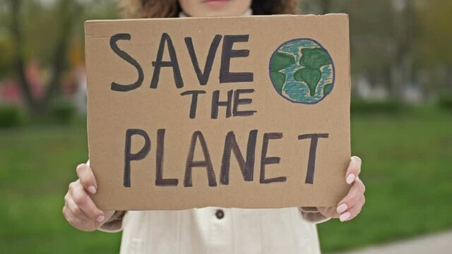 Woman with a poster SAVE THE PLANET. Feasible contribution to the fight against global pollution of nature. Single picket.