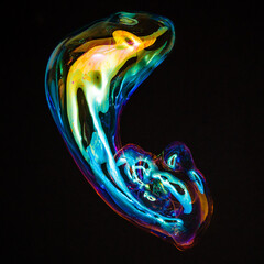 Amorphous and colorful isolated soap bubble with black background.