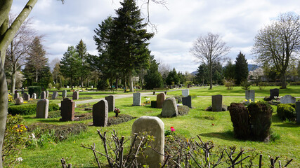 Friedhof mit alten Grabsteinen im Frühling, Park