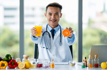 Asian nutritionist showing orange and juice