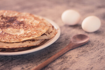 Plate with homemade pancakes. Selective focus. Old wooden table for cooking. - obrazy, fototapety, plakaty