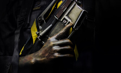 soldier's hand in camouflage and grasp the grip of the gun