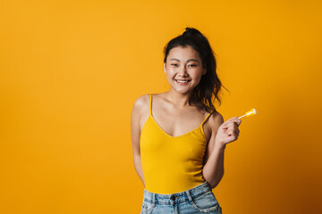 Happy young asian woman with a lollipop
