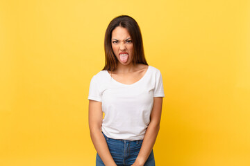 young hispanic woman feeling disgusted and irritated and tongue out