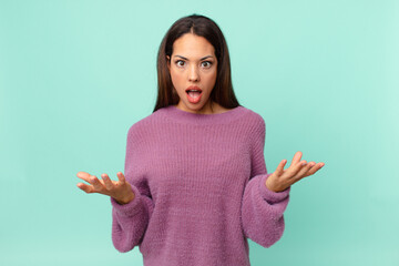 young hispanic woman feeling extremely shocked and surprised