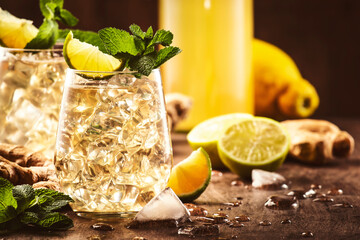 Ginger Ale Alcoholic Cocktail with Beer, Lime, Lemon and Mint Leaves in glaass on wooden table