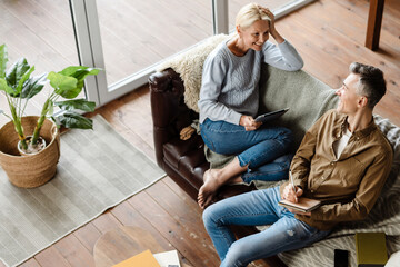 Smiling middle aged white couple relaxing on a couch