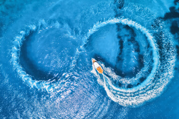 Aerial view of the speed boat in clear blue water at sunny day in summer. Top view from drone of...