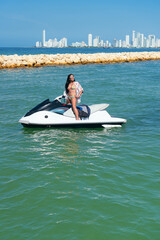 African woman in bikini standing on an jet ski