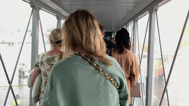 Passengers boarding plane at bridge. Crowd people standing waiting to enter airplane