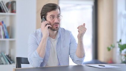 Man in Glasses Talking on Smartphone in Office 