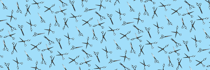 Background of black scissors. professional hairdresser black scissors isolated on blue. Black barber scissors, close up. pop art background, for prints or posters. not seamless pattern