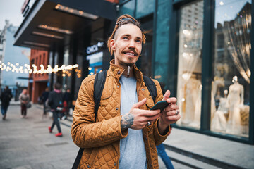 Dreamy young man looking up and smiling outdoors