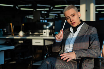 Business woman with short hair sits by the window and writes on a digital tablet with a stylus pen