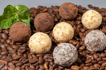 Chocolate candies on a gray background with reflection. Piece by piece and as a whole. Filling of nuts and fruits.